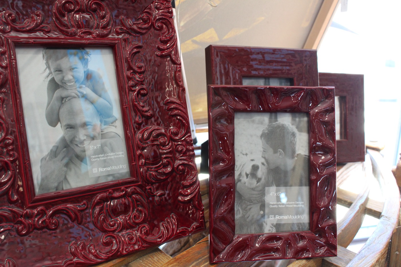 Framed landscape pieces displayed against an exposed brick wall